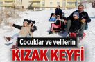 Kızakla kayarak eğlenen çocuklara velileri de eşlik etti